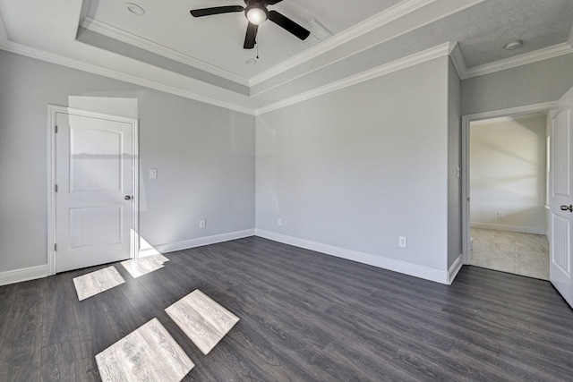 empty room with crown molding, dark wood-type flooring, a raised ceiling, and ceiling fan