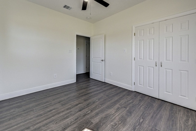 unfurnished bedroom featuring dark wood-type flooring, ceiling fan, and a closet