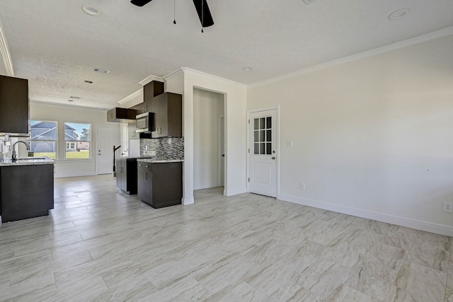 kitchen featuring crown molding, a textured ceiling, backsplash, and ceiling fan