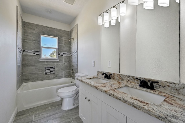 full bathroom featuring vanity, tiled shower / bath combo, a textured ceiling, and toilet