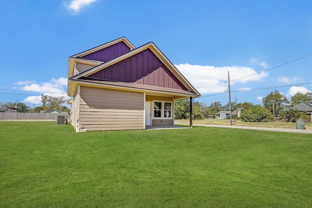 rear view of house featuring a lawn and central AC unit