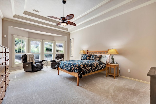 carpeted bedroom with a raised ceiling, ceiling fan, and crown molding