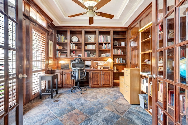 office with a tray ceiling, crown molding, ceiling fan, and built in desk