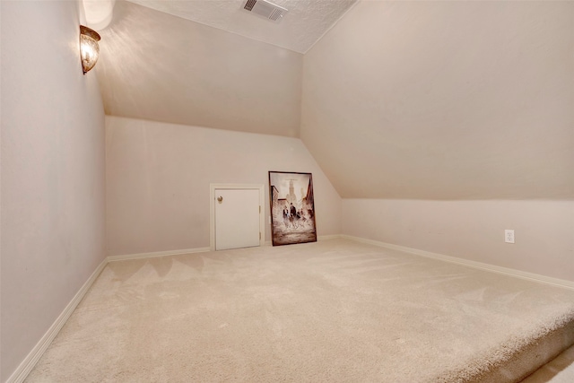 additional living space featuring carpet and lofted ceiling