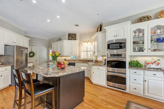 kitchen featuring light hardwood / wood-style flooring, white cabinets, and stainless steel appliances