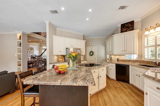 kitchen with black appliances, white cabinetry, light wood-type flooring, and a kitchen island