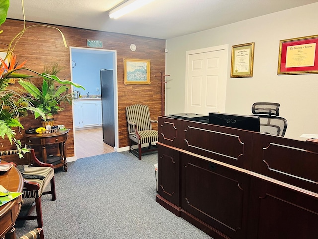 interior space featuring wood walls and light colored carpet