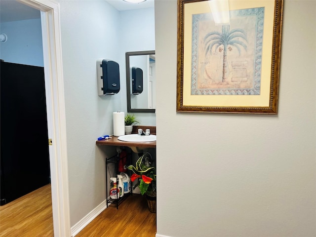 hall with hardwood / wood-style floors and sink