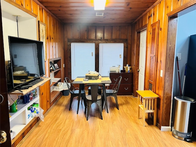 dining room featuring light hardwood / wood-style floors and wooden ceiling