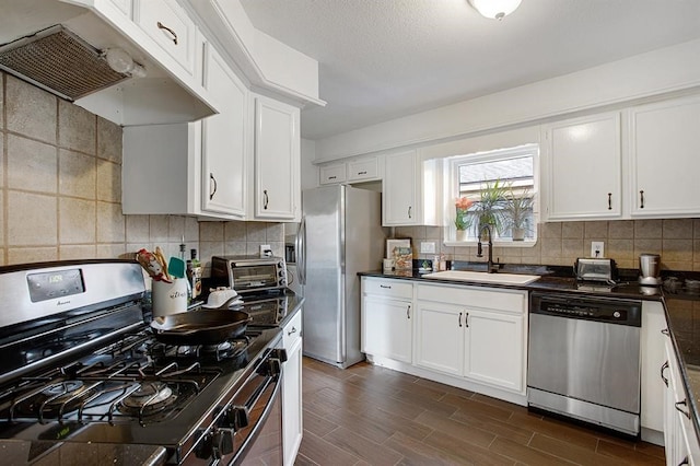 kitchen with white cabinets, tasteful backsplash, dark hardwood / wood-style flooring, sink, and stainless steel appliances