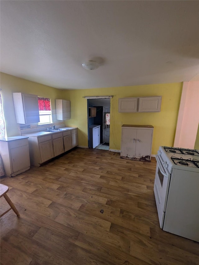 kitchen featuring white range with gas stovetop and dark hardwood / wood-style floors