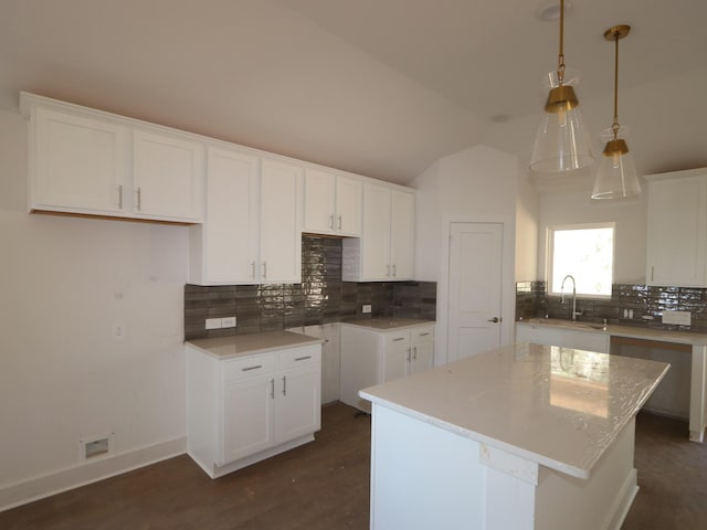 kitchen with white cabinetry, a center island, and sink