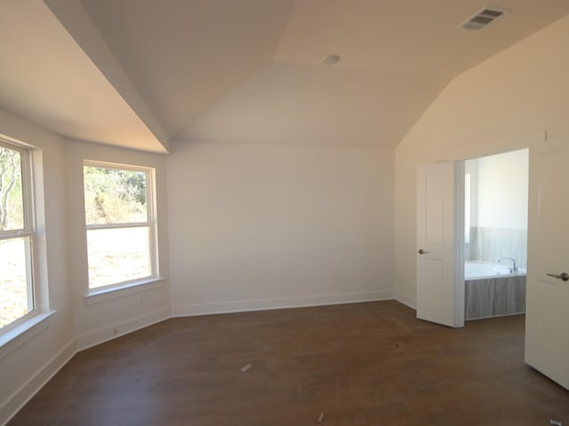 spare room with lofted ceiling and dark hardwood / wood-style floors