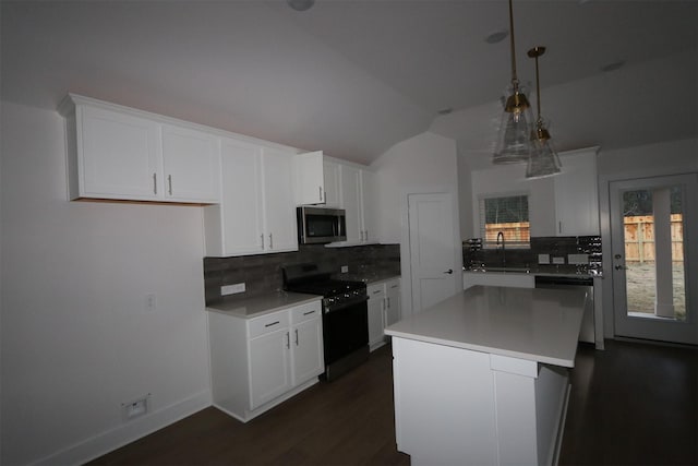 kitchen with decorative light fixtures, stainless steel appliances, white cabinets, a sink, and a kitchen island