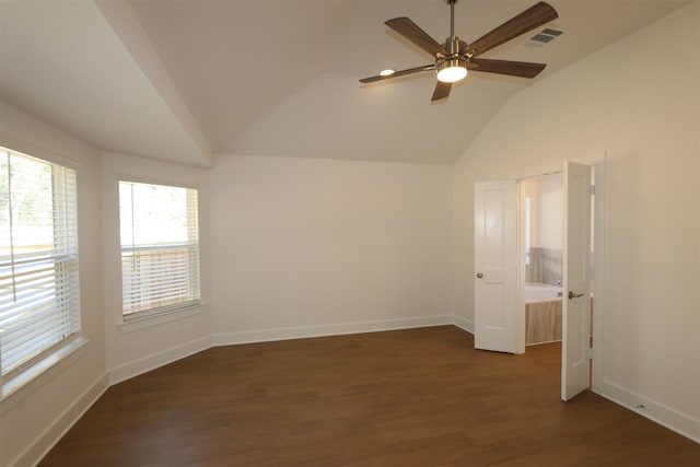 empty room featuring vaulted ceiling, visible vents, dark wood finished floors, and baseboards