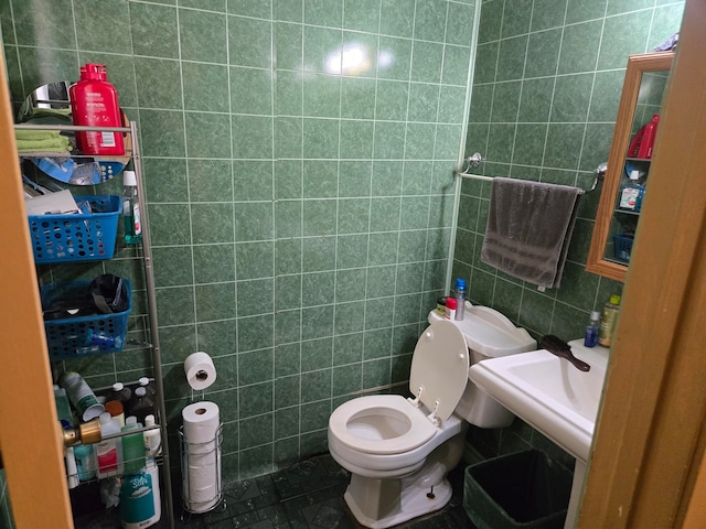 bathroom featuring toilet and tile walls