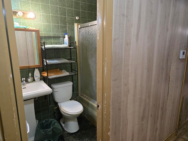 bathroom with toilet and tile walls