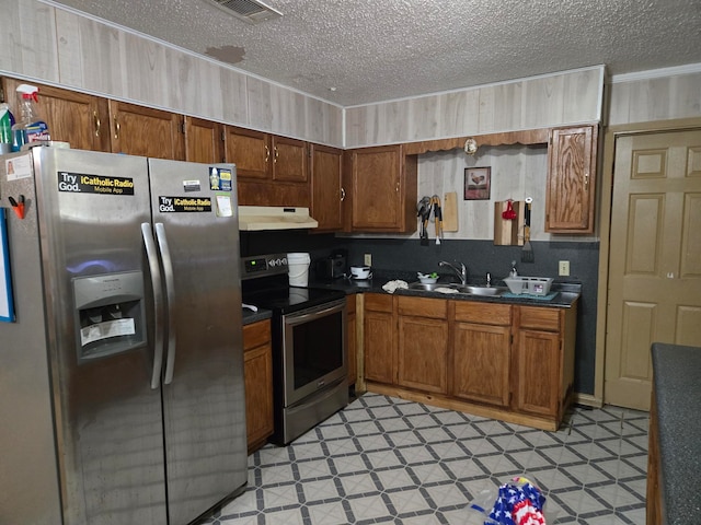 kitchen with a textured ceiling, stainless steel appliances, and sink