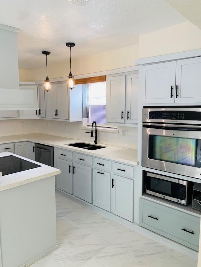 kitchen featuring stainless steel appliances, sink, pendant lighting, gray cabinets, and a textured ceiling