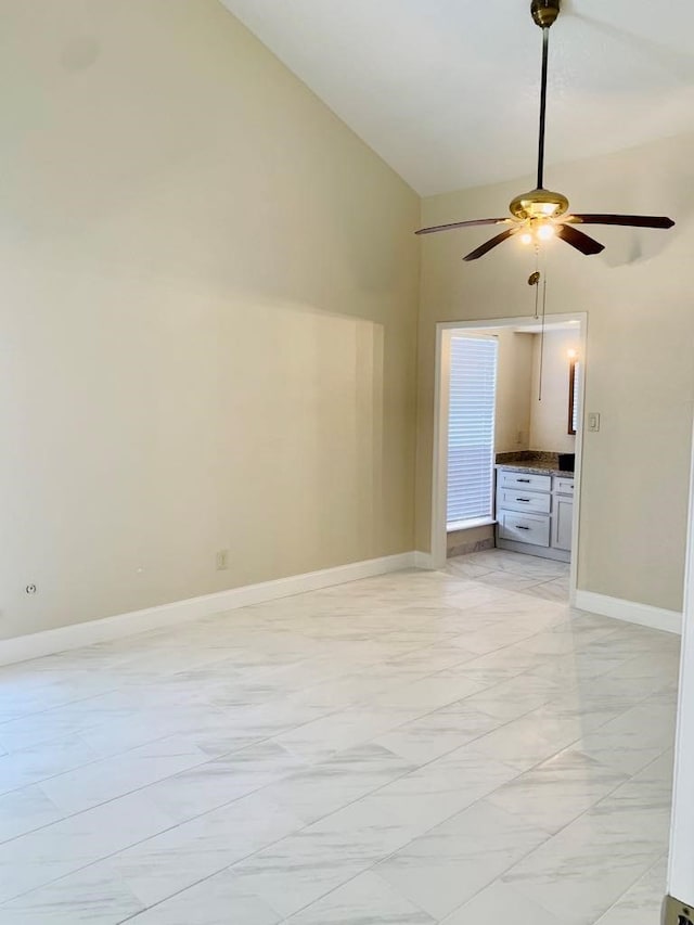 spare room featuring high vaulted ceiling and ceiling fan