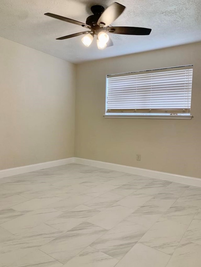 empty room featuring ceiling fan and a textured ceiling