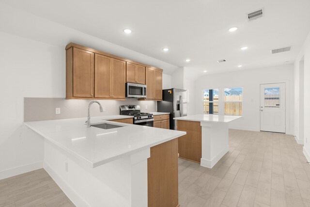 kitchen with kitchen peninsula, a breakfast bar, stainless steel appliances, and sink