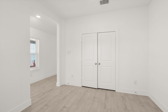 unfurnished bedroom featuring a closet and light wood-type flooring