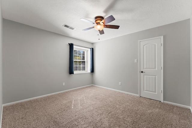 carpeted empty room featuring ceiling fan and a textured ceiling