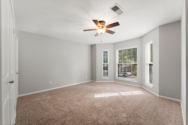 carpeted empty room featuring ceiling fan and a textured ceiling