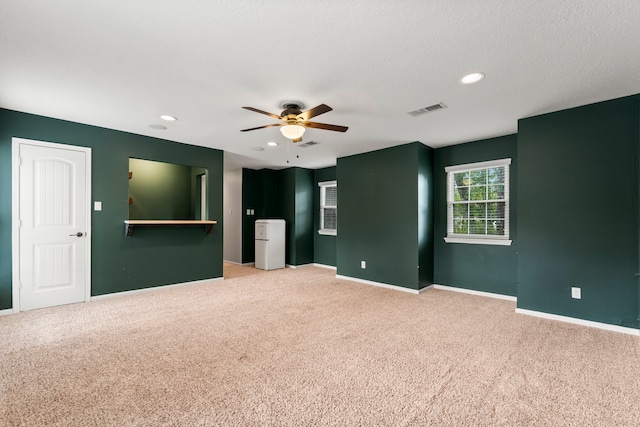 carpeted empty room featuring a textured ceiling and ceiling fan