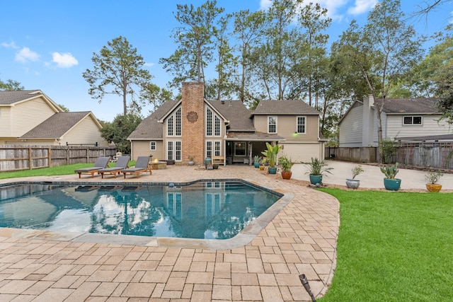 view of pool with a patio area and a yard