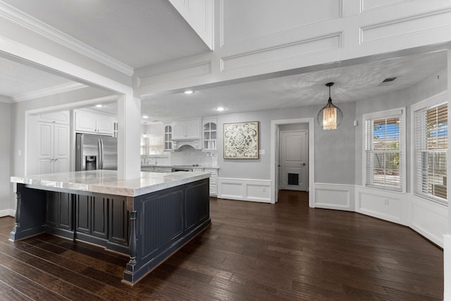 kitchen with stainless steel fridge, dark wood-type flooring, decorative light fixtures, a center island, and white cabinetry