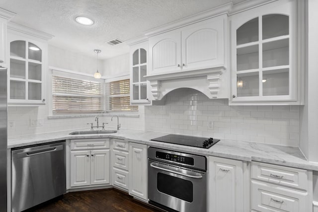 kitchen with pendant lighting, white cabinets, sink, a textured ceiling, and stainless steel appliances