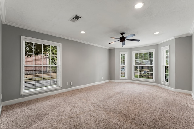 empty room with carpet flooring, crown molding, ceiling fan, and a healthy amount of sunlight