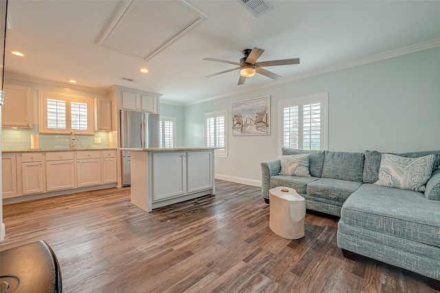 living room featuring crown molding, hardwood / wood-style flooring, a healthy amount of sunlight, and ceiling fan