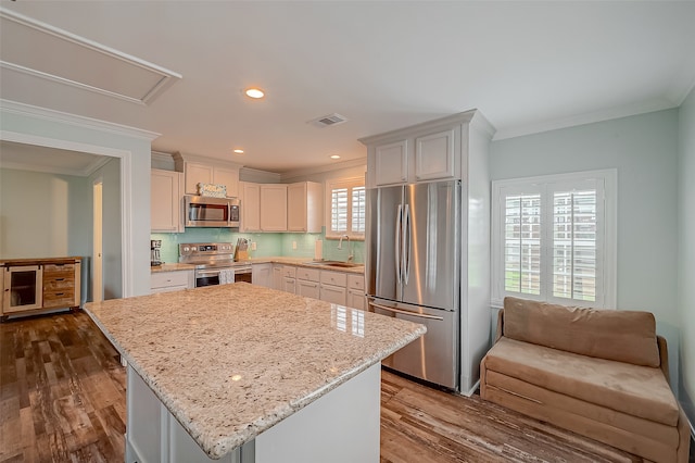 kitchen with sink, a center island, white cabinetry, appliances with stainless steel finishes, and dark hardwood / wood-style flooring