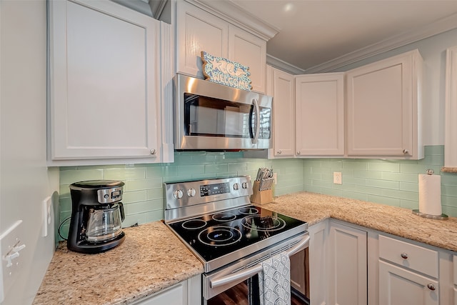 kitchen with appliances with stainless steel finishes, light stone counters, and white cabinetry