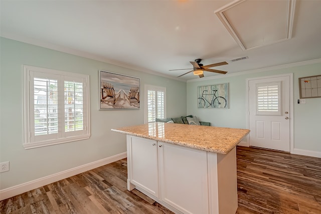 kitchen featuring ornamental molding, white cabinetry, dark wood-type flooring, and a kitchen island