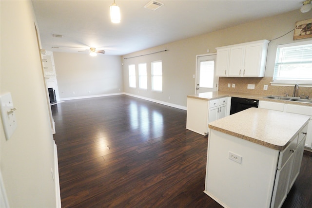 kitchen with dark wood-type flooring, sink, a center island, white cabinets, and ceiling fan