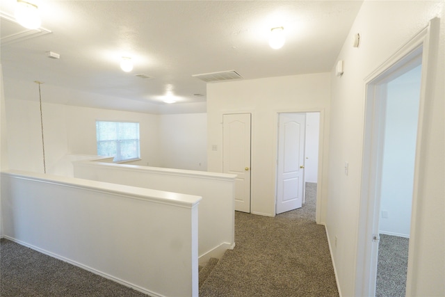 hallway with dark colored carpet