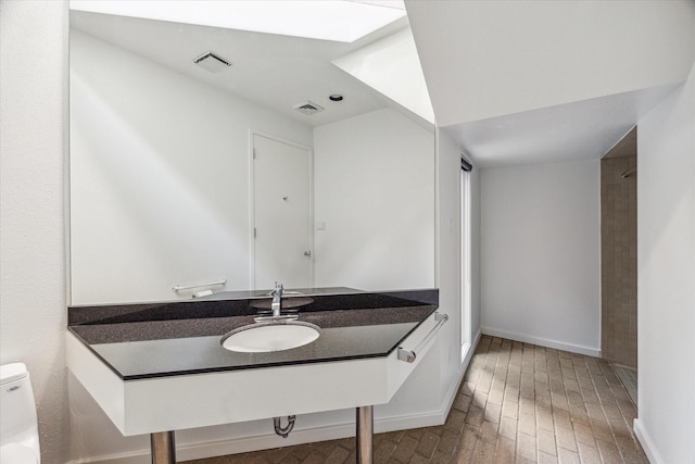 bathroom with hardwood / wood-style floors, vanity, and toilet