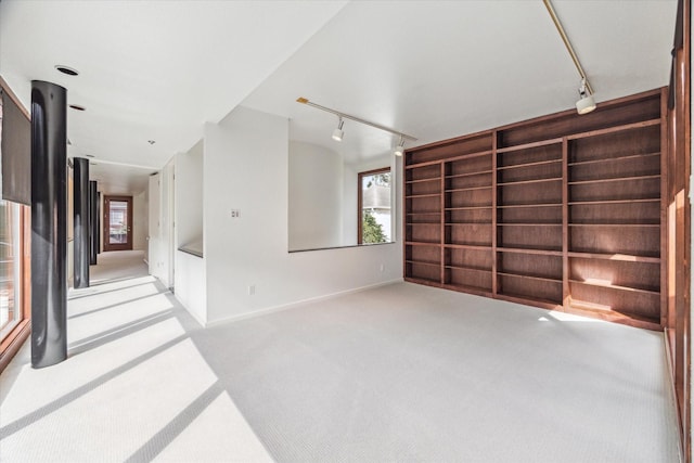 empty room with light carpet and track lighting