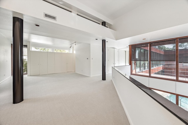 unfurnished room with light carpet and a high ceiling