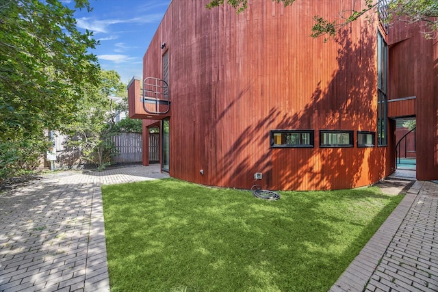 view of home's exterior featuring a yard and a balcony