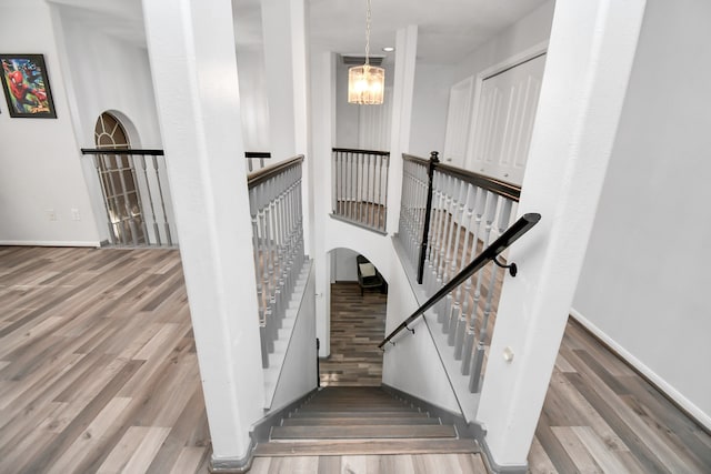 staircase featuring hardwood / wood-style flooring and a chandelier