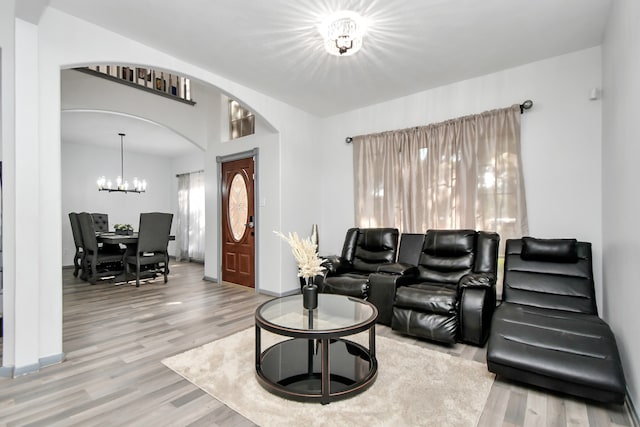 living room with an inviting chandelier and light wood-type flooring