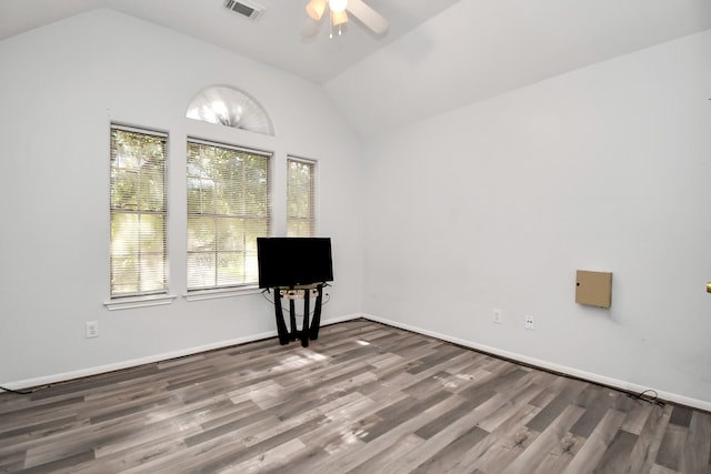 empty room featuring ceiling fan, dark wood-type flooring, and vaulted ceiling