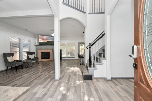 foyer entrance featuring light hardwood / wood-style flooring and a tiled fireplace