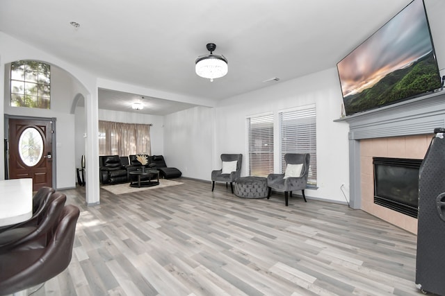 living room with light hardwood / wood-style floors and a tile fireplace