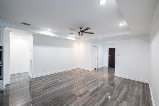 spare room featuring crown molding, dark hardwood / wood-style floors, a raised ceiling, and ceiling fan